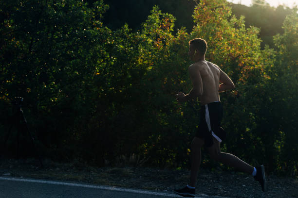 istock gym man jogging with cellphone on mountain road 1368103148