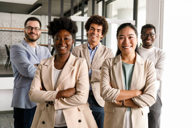 istock Five successful business people standing with arms crossed, smiling at camera 1368104305
