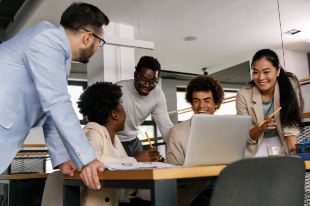 istock Five business people watching a funny video and laughing 1368104332