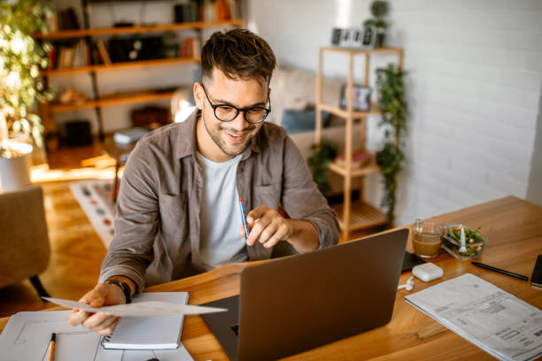 istock Young man doing home finances at home 1368105387