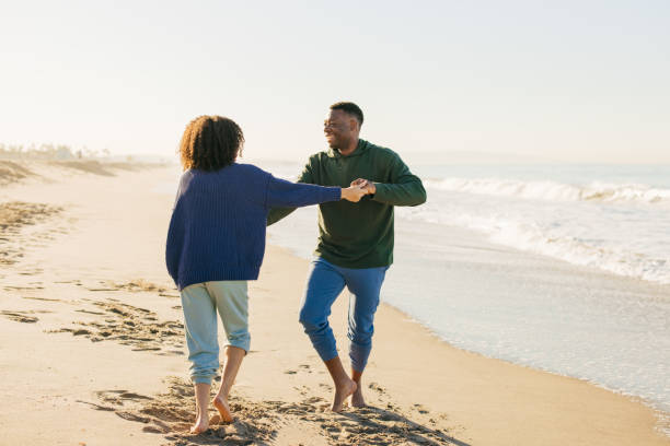 istock Smiling couple on the beach - joyful moment 1368107569
