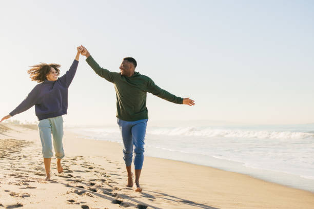 istock Smiling couple on the beach - joyful moment 1368107582