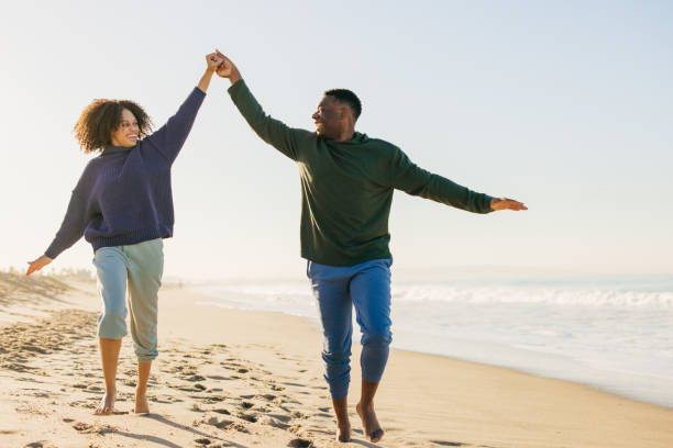 istock Smiling couple on the beach - joyful moment 1368107584