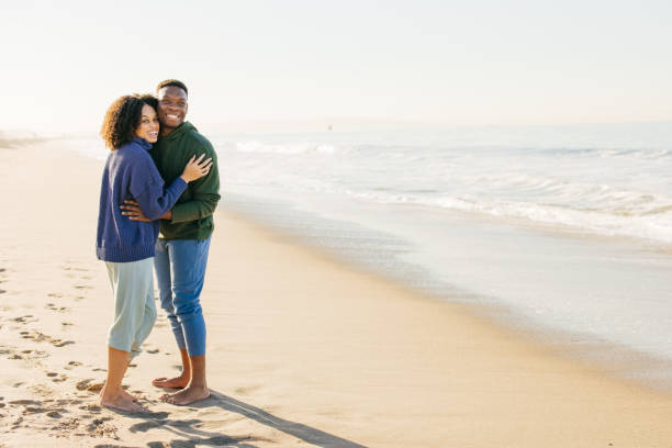 istock Smiling couple on the beach - joyful moment 1368107628