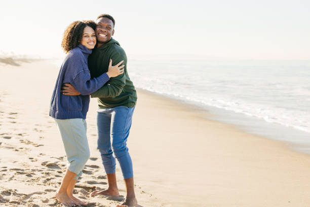 istock Smiling couple on the beach - joyful moment 1368107629