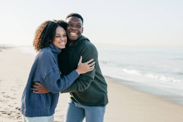 istock Smiling couple on the beach - joyful moment 1368107635