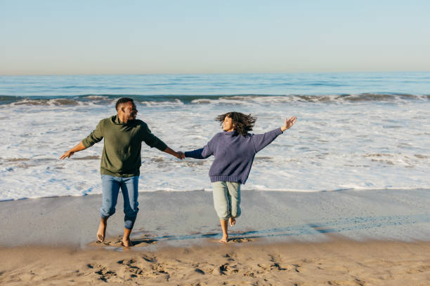 istock Smiling couple on the beach - joyful moment 1368107665