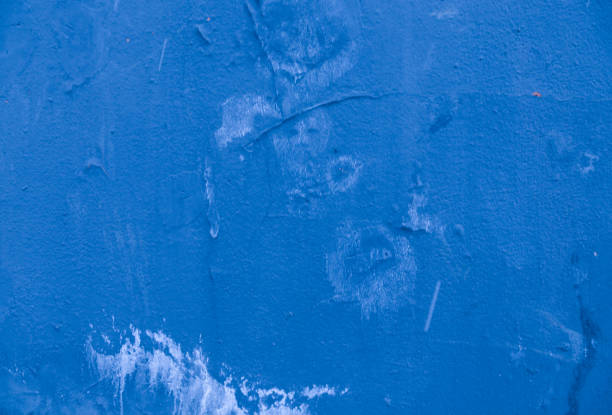 istock Weather damaged concrete wall covered in blue plaster. 1368110711
