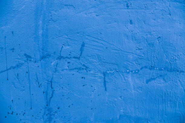 istock Damaged concrete wall covered with blue plaster. 1368110724
