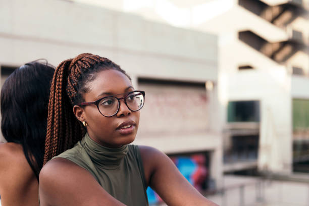 portrait of a young black woman sitting pensive - braids african descent women pensive imagens e fotografias de stock