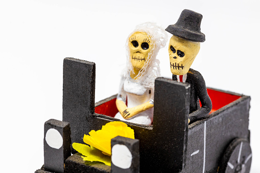 Traditional mexican dead couple riding a car on Day of the Dead isolated