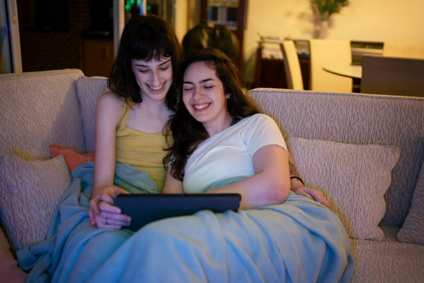 istock Lesbian couple watching video on digital tablet on the sofa. 1368113185