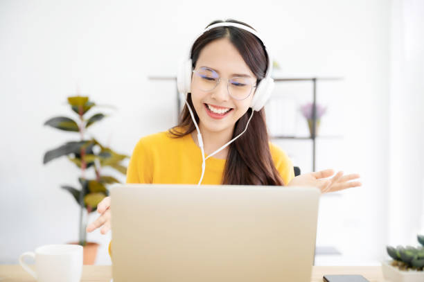 istock Asian young woman student wear wireless headset video conference calling on laptop computer talk by webcam learn teach in online chat, distance webinar online teaching concept 1368120306