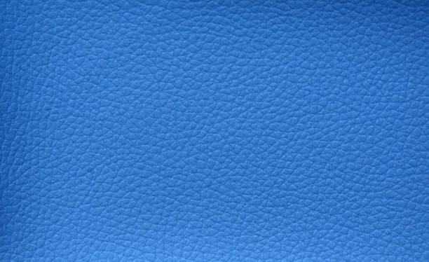 istock Fragment of natural leather with a small mesh pattern and artificially dyed in bright blue close-up. 1368123956