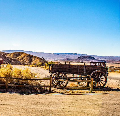 An old wagon stands by the roadway that travels to the Calico Hills Ghost town in California.