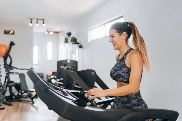 istock Smiling fitness woman using treadmill 1368133460