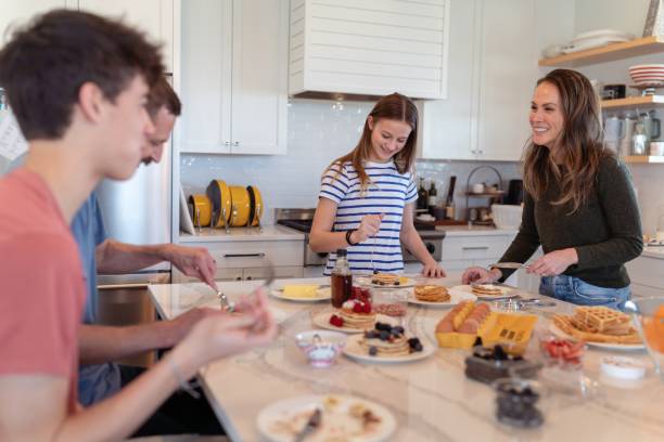 Happy family eating breakfast stock photo