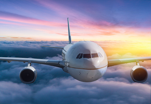 Body of an Airplane Flying Above Clouds at sunset