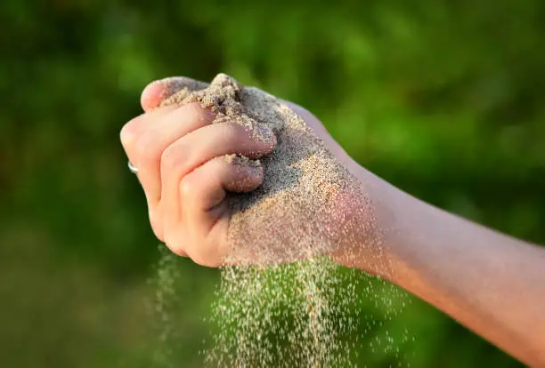 Sand in the Hand on the Nature Background closeup