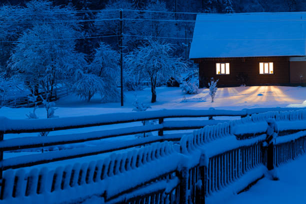 old house covered with snow in the evening