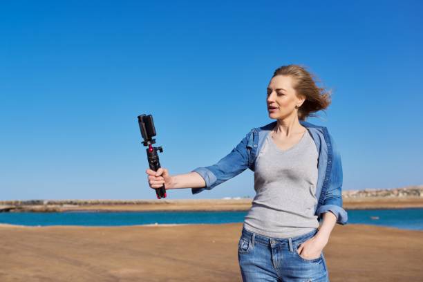 istock Middle aged woman on the beach talking online using smartphone. 1368145833
