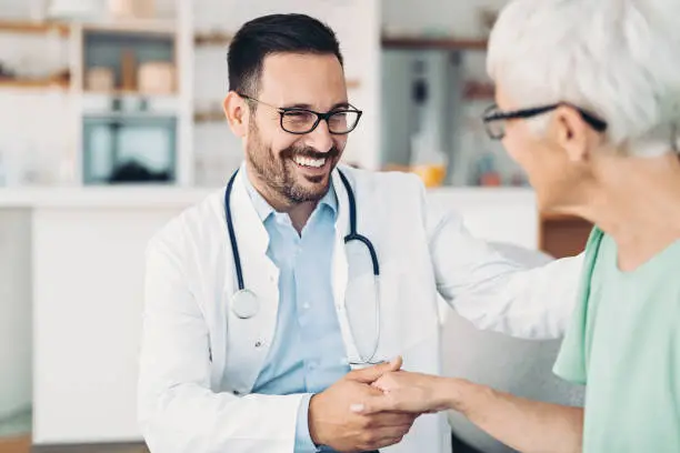 Photo of Smiling doctor with senior patient