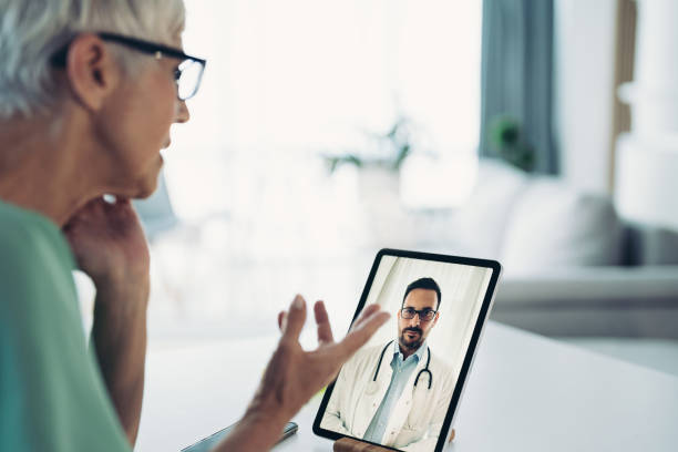 istock Senior woman using digital tablet to consult a doctor 1368148571