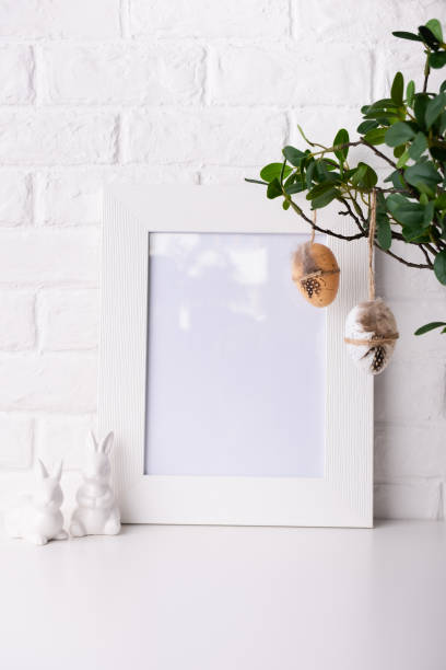 istock Mock up Photo frame near a white brick wall with Easter decor. 1368151073