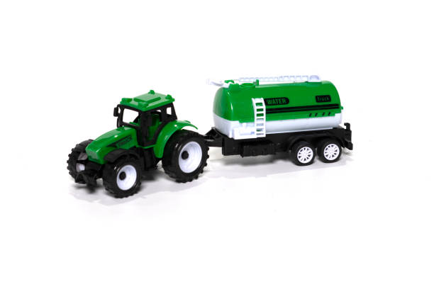 istock Green toy tractor with water trailer isolated on white background. 1368151382