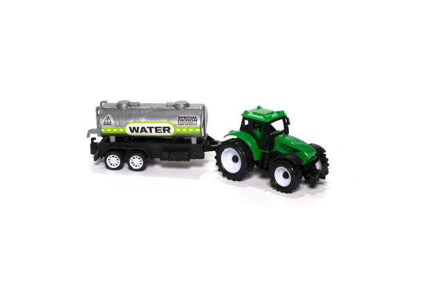 istock Green toy tractor with water trailer isolated on white background. 1368151391