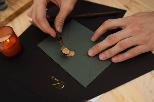 istock Male hands sealing dark green envelope with wax 1368152282