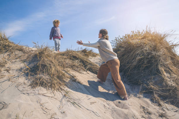 mother and daughter playing on the beach at the ocean in Denmark