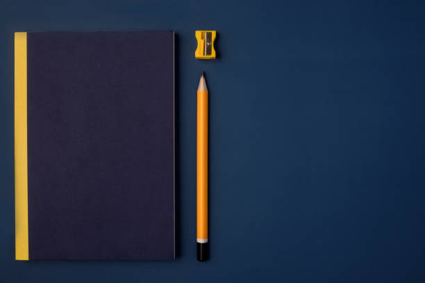 istock top view cover blue notebook with yellow pencil and notepad on navy blue working table 1368152329
