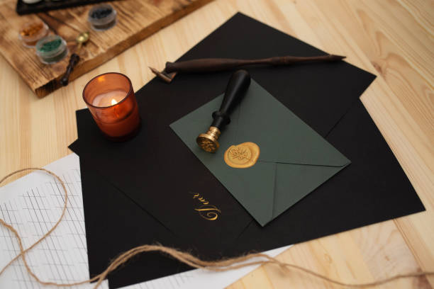 istock Calligraphy accessories, black paper and envelope lying on wooden table 1368153253