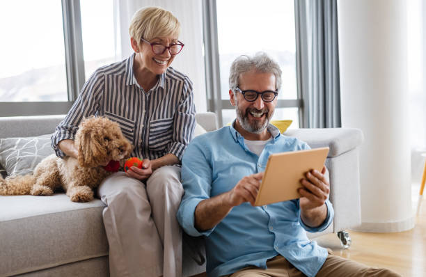 istock Happy smiling mature couple using digital tablet at home 1368155378