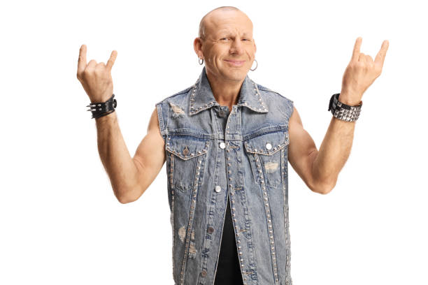 istock Bald man in a denim vest posing and gesturing rock and roll sign 1368155885