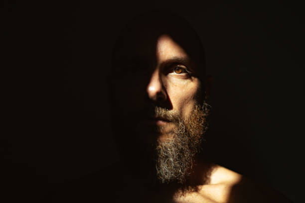 istock Dramatic light self portrait: bearded man in the shadow 1368156932