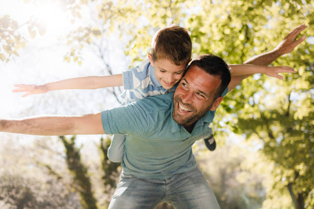istock Playful father having fun while piggybacking his son in nature. 1368157728