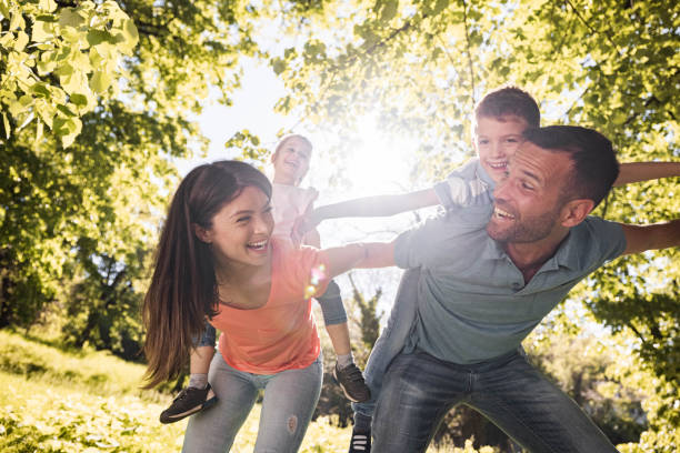 istock Playful family having fun while piggybacking in nature. 1368157745