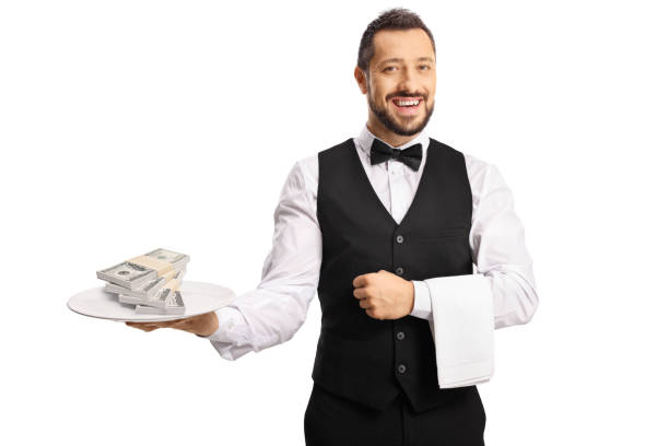 istock Male server holding a plate with stacks of money 1368157919