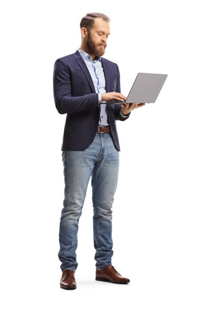 istock Young man in suit and jeans standing with an open laptop computer and working 1368159257