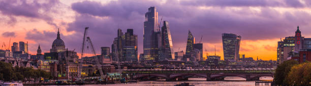 London City financial district skyscrapers St Pauls Thames sunrise panorama Golden light of sunrise illuminated the futuristic spires of City skyscrapers, the delicate span of the Millennium Bridge over the River Thames in the heart of London, UK. bankside photos stock pictures, royalty-free photos & images
