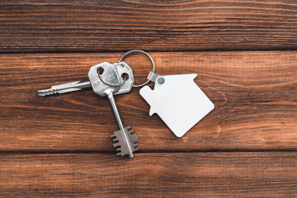 istock Keychain house shaped mockup on rustic wooden background. Blank white sublimation keychain. 1368159551