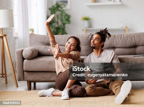 istock Young african american family couple planning home renovation, discussing design project on tablet 1368159552