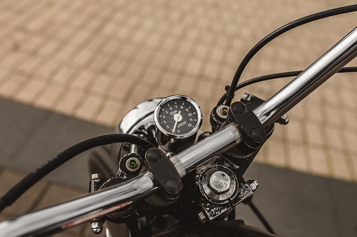 Round vintage speedometer on a motorcycle steering wheel - chrome detail in vintage style