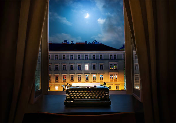 рабочее место писателя, журналиста, творца. старая пишущая машинка на столе на фоне старинных ночных городских построек. ретро стиль. понят� - urban scence стоковые фото и изображения