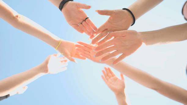 istock Cheerful girls join hands together as a sign of unity and joint successful work. Teamwork stacking hand concept 1368163307