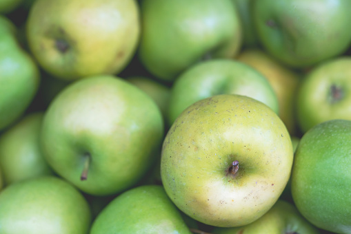 Fresh red apples with leaves on concrete background, top view