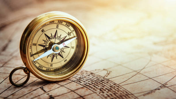 Magnetic old compass on world map. Travel, geography, navigation, tourism and exploration concept background. Treasure Island on the Pirate Map. stock photo