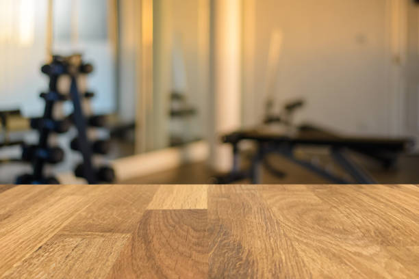 Empty old wood table in front of blurred background of the gym, fitness center. Can be used for display or montage for show your products. stock photo